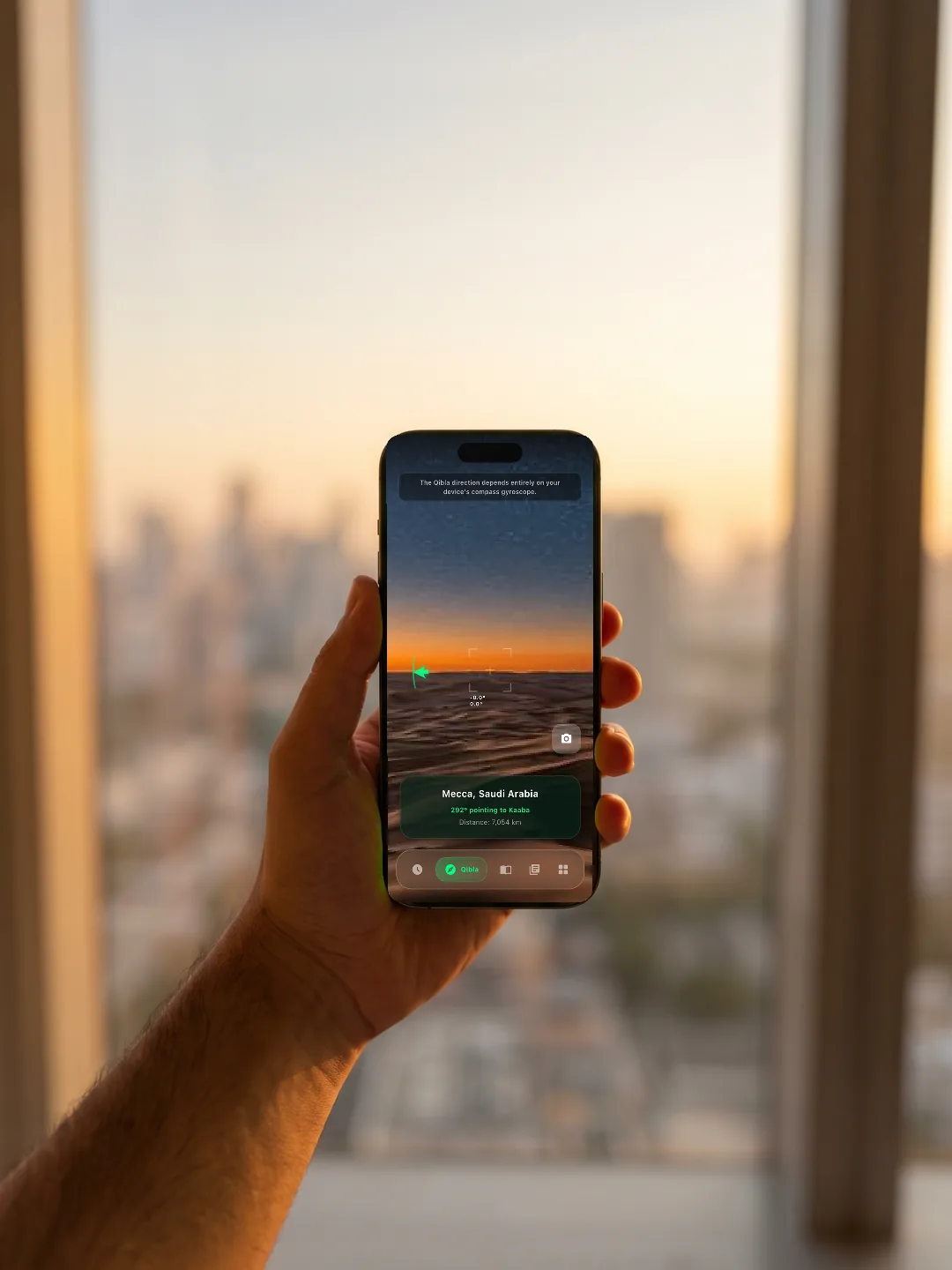 Tangan memegang iPhone dengan panorama kiblat